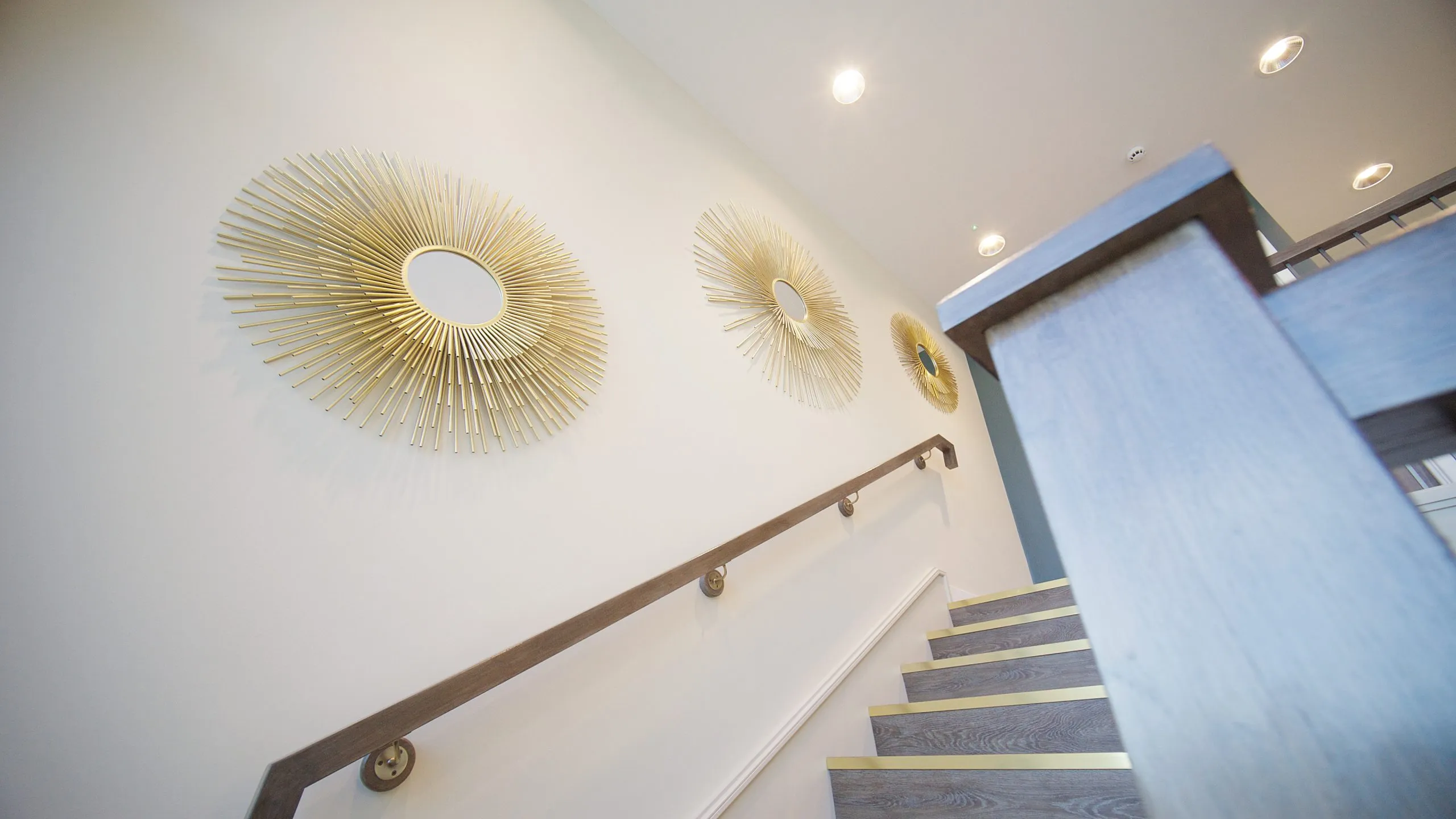 Staircase with gold sunburst wall art at Infinity Dental Suite, Harrogate