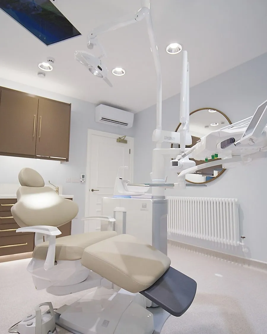 Surgery with walnut cabinetry, ceiling screen and abstract artwork at Infinity Dental Suite, Harrogate — one of many projects for Infinity Dental since 2018
